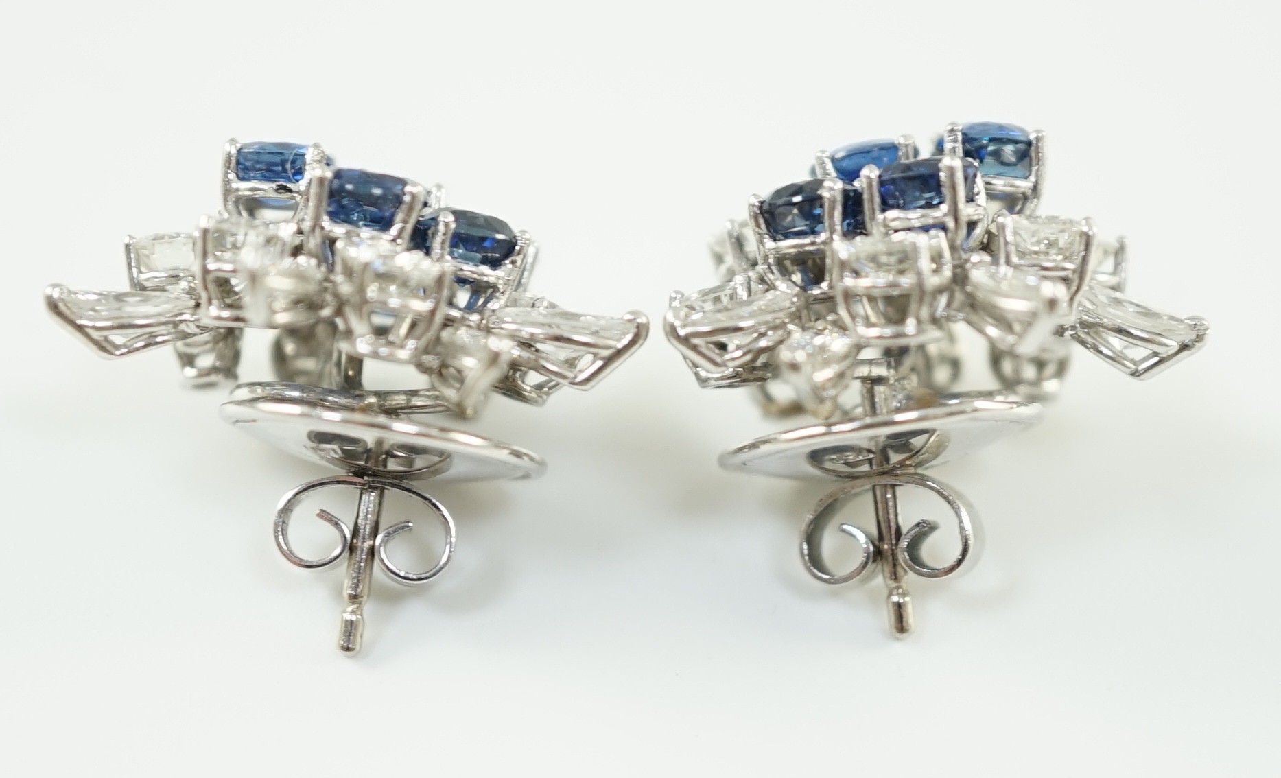 A pair of modern 750 white gold, set sapphire and diamond cluster ear studs